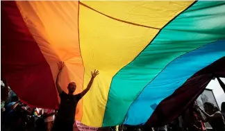  ?? ?? A man is seen underneath the rainbow flag during the the fourth gay pride rally in the Bulgarian capital of Sofia on Saturday, June 18, 2011
