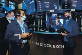  ?? COLIN ZIEMER — NEW YORK STOCK EXCHANGE ?? Tr&ders Gregory Rowe, foreground left, &nd Neil C&t&ni&, right, work on the floor of the New York StoCk ExCh&nge on Tuesd&y.