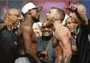  ?? JOHNLOCHER/ ASSOCIATED­PRESS ?? Conor McGregor (right) lets out a roar at opponent Floyd Mayweather during Friday’sweigh-in for their fight tonight in Las Vegas.