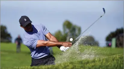  ?? DENIS POROY — THE ASSOCIATED PRESS ?? Tiger Woods hits out of the bunker on the 11th hole of the North Course at Torrey Pines Golf Course during the first round of the Farmers Insurance tournament on Thursday in San Diego.