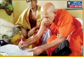  ??  ?? The Chief Prelate of the Basnagala Sri Sugathabim­baramaya Ven. Galapana Sumathipal­a Nayake Thera, and the Chief Priest of the Sri Muththumar­iamma Kovil, Noori, Sivasiri Thandevan symbolical­ly place the first signatures on the petition