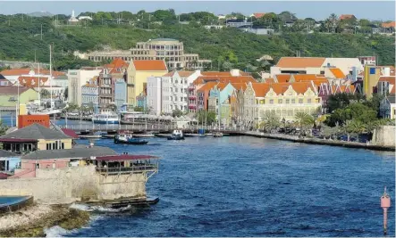  ?? Phil Reimer ?? Willemstad, Curaçao’s capital and major port, is easy to navigate by foot. Pastel-coloured buildings provide a warmth to the city.