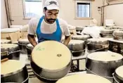  ?? ANTONIO CALANNI/AP ?? A worker creates wheels of Parmesan Reggiano cheese in Noceto, near Parma, Italy, last week.