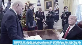  ??  ?? WASHINGTON DC: In this file photo taken on December 22, 2017 White House Chief of Staff John Kelly picks up documents off of United States President Donald J. Trump desk during an event to sign the Tax Cut and Reform Bill in the Oval Office at The White House. —AFP