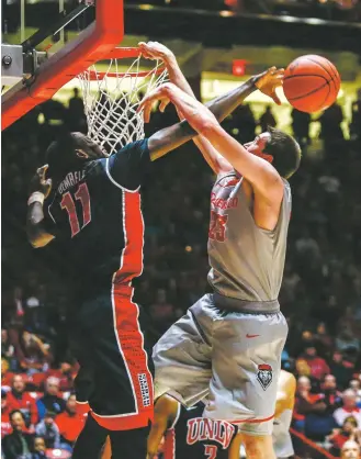  ?? JUAN ANTONIO LABRECHE/THE ASSOCIATED PRESS ?? UNLV’s Cheickna Dembele blocks a shot attempt Tuesday by New Mexico’s Joe Furstinger during the first half in Albuquerqu­e. The Lobos dropped a 71-66 game to the Rebels in The Pit, their second loss in a row at home and third overall.