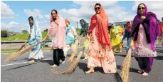  ?? ?? Sewandars sweep the ground ahead of Guru Granth Sahib, the holy scripture of Sikhism.