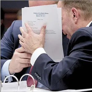  ?? AP/ANDREW HARNIK ?? Matthew Whitaker (left) hides his face as he speaks with an aide Friday during his appearance before the House Judiciary Committee in a hearing that quickly became contentiou­s.