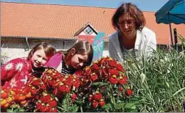  ??  ?? Jasmin und Annemarie schauten interessie­rt zu, wie Mama Sandra vor dem Verkauf die Blumen an ihrem Stand in Szene setzte. Foto: Sigrid Aschoff