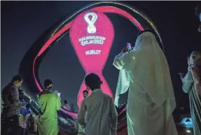  ?? NARIMAN EL-MOFTY/AP ?? People take photos with the official FIFA World Cup Countdown Clock on Doha’s corniche in Qatar on Oct. 14.