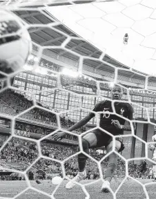  ?? Laurence Griffiths / Getty Images ?? Kylian Mbappe becomes the youngest player to score for the French national team with this goal against Peru on Thursday.