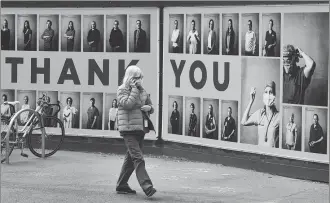  ?? WILLIAM WEST / AFP ?? A woman walks past a tribute to healthcare workers outside a hospital in Melbourne on Tuesday, when the hard- hit Victoria state recorded just one more COVID- 19 case.