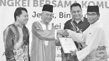  ??  ?? Talib presents a certificat­e of appreciati­on to Penghulu Drahman Kawi as Morris (left) and Timothy (second right) look on.