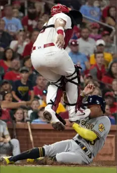  ?? Associated Press ?? Milwaukee’s Kolten Wong, bottom, scores past Cardinals catcher Andrew Knizner in the fourth inning Thursday night in St. Louis.