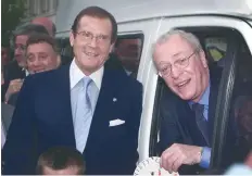  ?? — AFP file photo ?? This photo taken on April 12, 2000 shows British Oscar winner Michael Caine and actor Roger Moore (L) as they pose after presenting a mini-coach to a children’s charity in London.