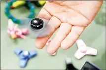  ??  ?? In this May 11, 2017 file photo, Funky Monkey Toys store owner Tom
Jones plays with a fidget spinner in Oxford, Michigan. (AP)