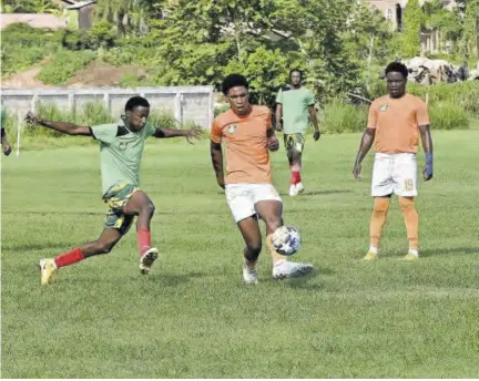  ?? (Photo: Paul Reid) ?? Ranaldo Brown (2nd right) of Lime Hall Academy gets rid of the ball before Wadada United’s Deshawn Talbert can get to him in Saturday’s JFF Tier II game at Irwin High School in St James. At right is Lime Hall’s Oniel Henry.