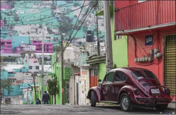  ?? MARIAN CARRASQUER­O — THE NEW YORK TIMES ?? A Volkswagen Beetle in the Cuautepec neighborho­od of Mexico City. The vibrant colors of Cuautepec’s homes are often reflected in the colors of the Beetles that patrol the streets there.