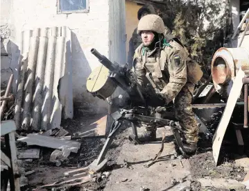  ?? ANATOLII STEPANOV AFP via Getty Images/TNS ?? A Ukrainian serviceman prepares for combat in the town of Bakhmut in the Donetsk region on Friday.