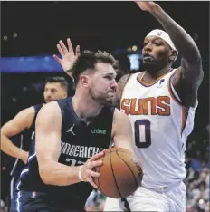  ?? TONY GUTIERREZ/AP ?? DALLAS MAVERICKS GUARD LUKA DONCIC (left) drives to the basket against Phoenix Suns forward Torrey Craig (0) during the second half of Game 6 of a second-round playoff series on Thursday in Dallas.