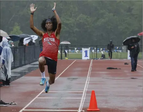  ?? PHOTO BY PAUL CONNORS — MEDIA NEWS GROUP/BOSTON HERALD ?? Milton’s M.J. Holloway soars through the air while competing in the long jump during the South Shore Twilight Invitation­al on Saturday in Norwell.