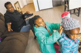  ?? Photos by Santiago Mejia / The Chronicle ?? Leola Brown, 69, and her grandchild­ren, Ziani Brown and Lenia Brown, prepare for their day in their affordable home at Bridge Housing.