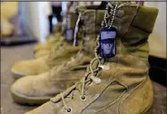  ?? Matthew Jonas
Staff Photograph­er ?? /
A portrait of U.S. Marine Corps Lance Corporal Wesley G. Davids is seen on his boots in the Eyes of Freedom exhibit at the Lyons Community Library.