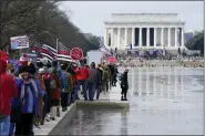  ?? PATRICK SEMANSKY — THE ASSOCIATED PRESS ?? People march alongside the Lincoln Memorial Reflecting Pool before an anti-vaccine rally on Sunday in Washington.