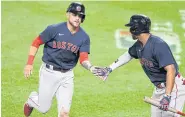 ?? AFP ?? The Red Sox’s Michael Chavis, left, celebrates scoring on a wild pitch in the 10th inning with Xander Bogaerts.