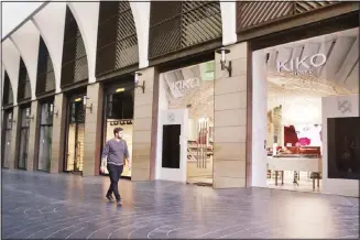  ??  ?? In this file photo, a man walks past closed shops after authoritie­s ordered the closure as part of preventive measures against the coronaviru­s, inside the upscale Beirut Souks shopping mall in Beirut, Lebanon. (AP)