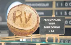  ??  ?? A loaf of sourdough bread with personalis­ed initials sliced on the top sits on the bread counter in the roastery and bake hall.