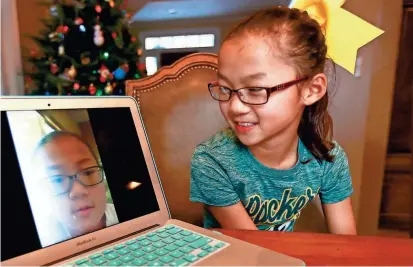  ?? T’XER ZHON KHA / USA TODAY NETWORK-WISCONSIN ?? Audrey Doering talks with her twin sister, Gracie Rainsberry, through FaceTime at her house in Wausau. Gracie lives in Richland, Wash. The girls just spoke for the first time this month.