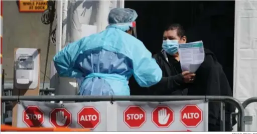  ?? BRYAN R. SMITH / EFE ?? Un sanitario habla con un hombre en el hospital de campaña instalado en Nueva York tras someterse a un test de coronaviru­s.