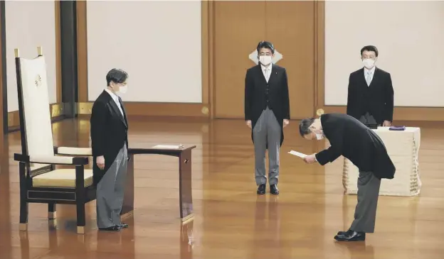  ?? PICTURE: AFP/GETTY IMAGES ?? 0 Japan’s new prime minister Yoshihide Suga bows to Emperor Naruhito as outgoing prime minister Shinzo Abe , centre, looks on