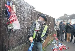  ?? Picture: PA. ?? Iain Gordon pulls down flowers on a fence opposite the house of Richard Osborn-Brooks.