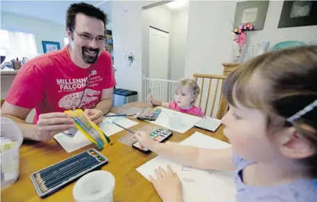  ?? Jonathan Hayward, Canadian Press ?? Stay-at-home dad Kevin Pratt enjoys spending time doing art with his two daughters Ruby, 4, and Annie, 2, at their home in Langley, B.C.