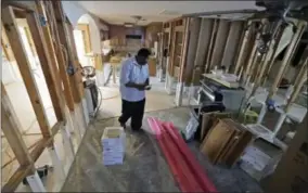  ?? DAVID J. PHILLIP - THE ASSOCIATED PRESS ?? George Dorsey walks through his hurricane-damaged home in Houston on Nov. 17. He usually hosts a large Thanksgivi­ng dinner for family but is making other arrangemen­ts this year as he continues to recover from Hurricane Harvey.