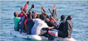  ??  ?? Crossing: Migrants in the Channel take photos of themselves