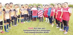  ??  ?? FAUZI (kiri) dan Jasri mempamerka­n jersi sumbangan Fauzi kepada pasukan JKSNS.