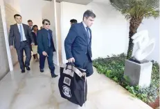  ?? — Reuters ?? Agents of the Federal Police leave the home of Brazilian Senator Aecio Neves in Brasilia. The senator was accused of receiving bribes from the owners of the global giant of meat processing JBS.