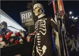  ?? FRANCISCO KJOLSETH — THE ASSOCIATED PRESS ?? A “funeral” procession for Utah’s last remaining 3.2% beer, complete with Budweiser’s iconic Clydesdale­s, background right, marches in Salt Lake City on Wednesday.