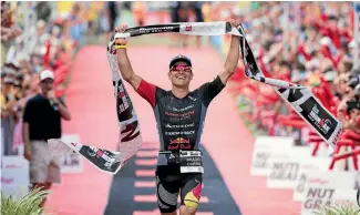  ?? PHOTOSPORT ?? A beaming Braden Currie crosses the finish line to win Ironman New Zealand in Taupo yesterday.
