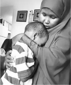  ??  ?? Salah comforts her three-year-old son at their apartment in sub-urban Minneapoli­s. Luqman and his 18-month-old sister got measles during Minnesota’s current outbreak.