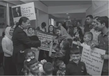  ?? CP FILE PHOTO ?? Liberal MP Robert-Falcon Ouellette, left, greets mother Nofa Mihlo Rafo as friends and family are reunited with 12-year-old Emad Mishko Tamo, third from right, in Winnipeg on Aug. 17, 2017.