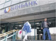  ?? REUTERS ?? People are seen outside the headquarte­rs of B&N Bank in Moscow, Russia, Sept. 20, 2017.