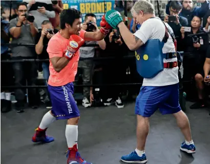  ?? AP ?? Manny Pacquiao (left) works out with trainer Freddie Roach at a boxing club in Los Angeles. —