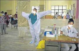  ?? PARVEEN KUMAR/HT ?? A health worker taking out his personal protective equipment at a community centre in Gurugram on Tuesday.