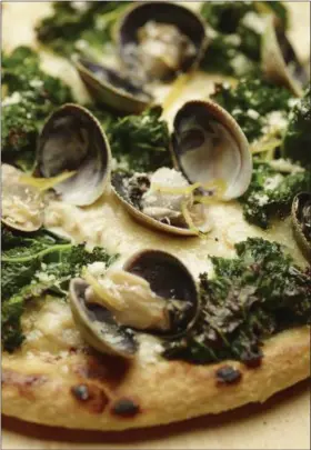  ?? PHIL MANSFIELD/THE CULINARY INSTITUTE OF AMERICA VIA THE ASSOCIATED PRESS ?? A photo provided by The Culinary Institute of America shows a grilled white pizza with cockles, lemon and kale.