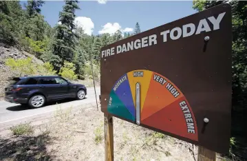  ?? PHOTOS BY LUIS SÁNCHEZ SATURNO/THE NEW MEXICAN ?? A sign indicates high fire danger Tuesday in Hyde Park. The National Weather Service says it will issue Wednesday a red flag warning, the highest for fire danger.