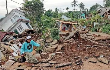 ?? AP ?? A youth navigates his way through the rubble at a village affected by Monday’s earthquake in Cianjur, West Java. More rescuers and volunteers were deployed yesterday.
