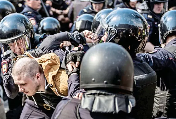  ?? ?? HEAVY HANDED: A man is arrested by riot police in a demonstrat­ion against Putin